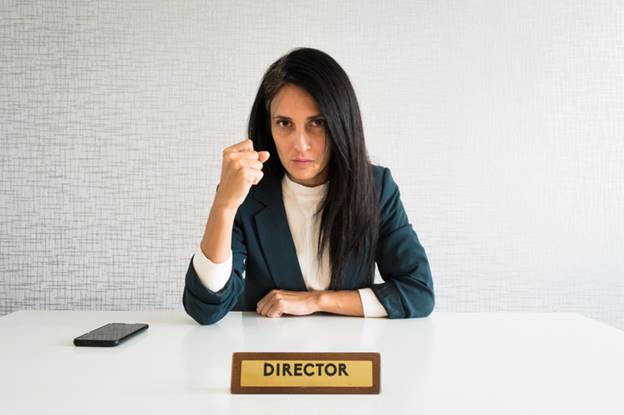Woman making first with Director sign in front of her - Employment Law